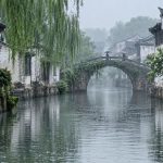 A Jiangnan canal town with wet tiled roofs and steady Meiyu rain