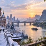 Visual contrast between snowy northern China and a mild green southern Chinese riverside