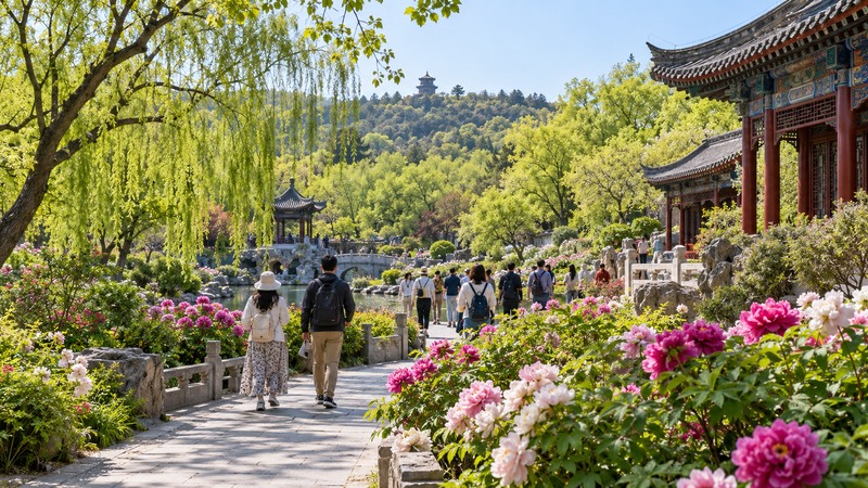 Visitors in light layers walking through a green northern Chinese garden in May